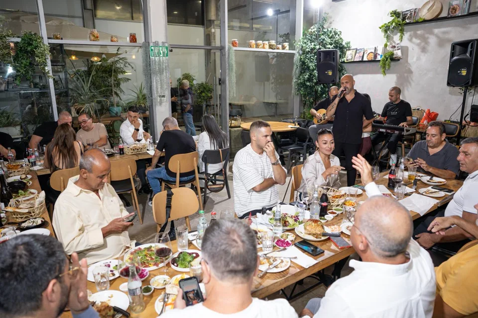 אורחים חוגגים סביב שולחן ארוך